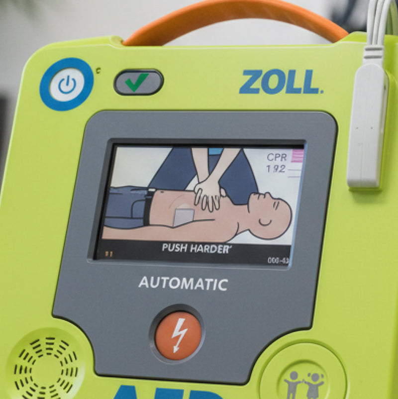 Close-up of a ZOLL AED defibrillator screen showing CPR instructions with hands pressing on a chest and "Push Harder" prompt.