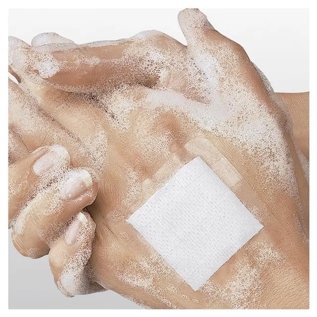 Leukoflex Tape applied on hand with soap lather, showcasing adhesive fabric tape for sensitive skin in first aid use.